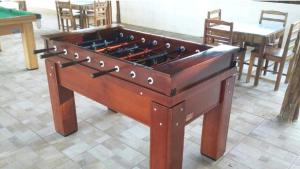 巴雷里尼亚斯Chalé Descanso的一张大型木制桌上足球,坐在地板上