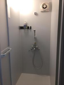 宫崎Accommodation Service B&B的一间带淋浴的浴室,墙上装有软管