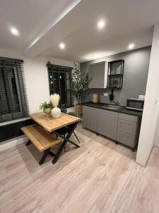 蒂尔堡Gezellig appartement, Gerenoveerd eind 2022的厨房铺有木地板,配有木桌。