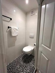 蒂尔堡Gezellig appartement, Gerenoveerd eind 2022的一间带卫生间的浴室,铺有黑白地板。