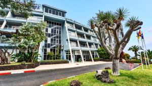 圣乌尔苏拉Coral La Quinta Park Suites的前面有棕榈树的建筑