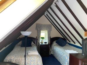 斯特灵Loch Arklet House的阁楼卧室设有两张床和窗户。