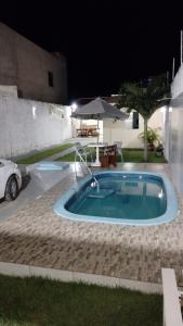 阿拉卡茹CASA DE TEMPORADA RECANTO FELIz 2的夜间在院子里的小游泳池