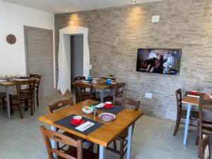 布多尼Sa Domo De Rosa的砖墙上的带木桌和电视的用餐室