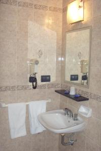罗萨里奥伊姆巴加多酒店的浴室配有盥洗盆、镜子和毛巾