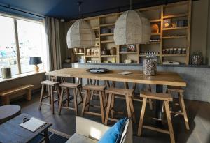 圣马洛Otonali Hôtel by Breizh Café的一间带木桌和凳子的用餐室