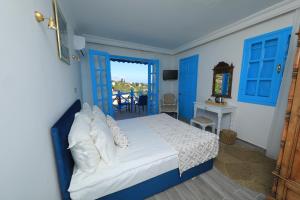 凯里尼亚Bellapais Abbey Boutique Hotel的一间带蓝色门和一张床的卧室以及一个阳台
