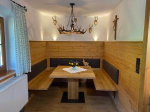基姆湖畔贝尔瑙Ferienwohnung Jagdhäusl的一间带木桌和吊灯的用餐室