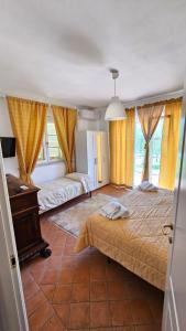 萨尔扎纳B&B Luna Nuova的一间卧室设有两张床、一张桌子和窗户。