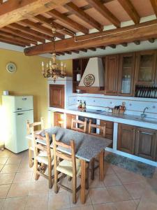 富切基奥Villa Donnola: casa Rosmarino的厨房配有桌子、椅子和冰箱。