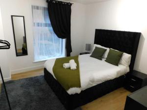 曼彻斯特2 Bed Modern Apartment Manchester City Centre的一间卧室配有一张带绿色和白色枕头的大床
