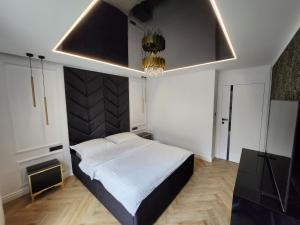 格但斯克Marina Apartments的一间卧室配有一张大床和一个吊灯。
