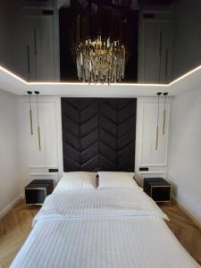 格但斯克Marina Apartments的一间卧室配有一张大床和一个吊灯。
