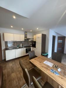 黑马戈尔Terezia-Appartements Nassfeld的厨房以及带木桌和椅子的用餐室。