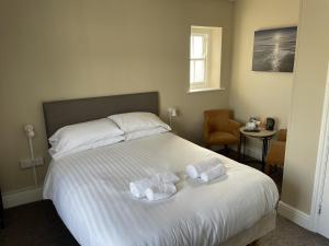 圣奥斯特尔康沃尔公爵酒店的一间卧室配有一张床,上面有两条毛巾