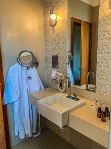 龙多诺波利斯Hotel Piratininga Avenida Amazonas - Rondonópolis的一间带水槽和镜子的浴室