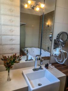 龙多诺波利斯Hotel Piratininga Avenida Amazonas - Rondonópolis的一间带水槽和大镜子的浴室