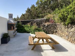 巴尔韦尔德Casa Armonía del Silencio的木凳坐在石墙旁的庭院