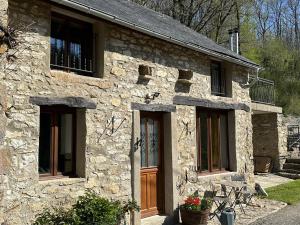 Le Cottage at The Moulin Treillard的石屋,设有木门和窗户