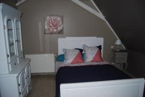 OssunLa Ferme aux Fleurs的卧室配有带红色枕头的白色床