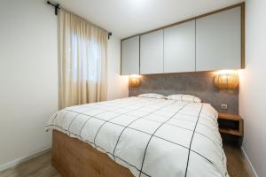 德拉格Tiny home Rubi in Oaza Mira resort的卧室配有白色大床和白色橱柜