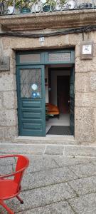 吉马良斯Alojamento Local F&B的前面有红椅的绿色门