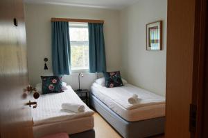 Sólheimar索海姆生态村旅馆的一间卧室设有两张床和窗户。