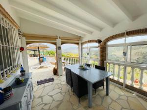 比纽埃拉Villa Casira met 2 studio's - 10 personen, Viñuela, Costa Del Sol的厨房配有桌椅和窗户。