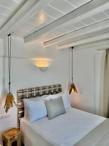 米克诺斯城Sofos Suites Mykonos的卧室配有白色的床铺和白色的枕头