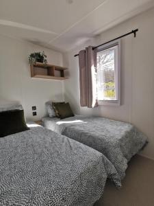 ReisdorfChalet Hohllay的一间卧室设有两张床和窗户。