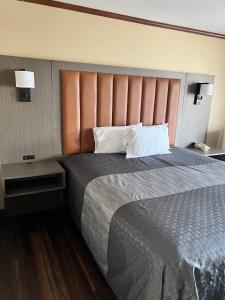 拉斯维加斯高地拉斯维加斯酒店的一间卧室配有一张大床和大床头板