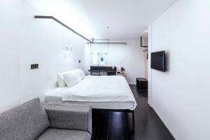 新加坡Hotel Mono的一间卧室配有一张床和一张沙发