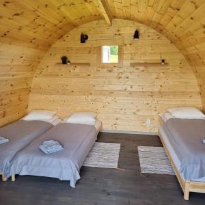 尤尔巴尔卡斯Camp Genys的木墙客房的两张床