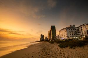 斯特兰德海风酒店 的日落时分拥有建筑和海洋的海滩