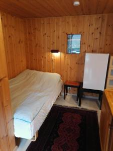 HaugsværSognevegen 2242的木制客房内的一间卧室,配有一张床