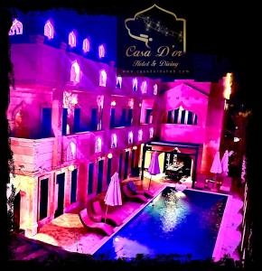 达哈布Casa d'Or Dahab PALAZZO的一座带游泳池和粉红色灯光的房子