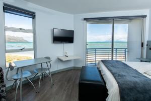 斯特兰德海风酒店 的一间卧室配有一张床、一张桌子和一台电视