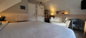 布里德灵顿The Mon Fort的卧室配有一张白色大床和一把椅子