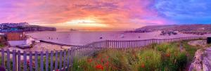 佩伦波斯Luxury Sunrise to Sunset Beachfront Apartment的享有带围栏和鲜花的海滩美景