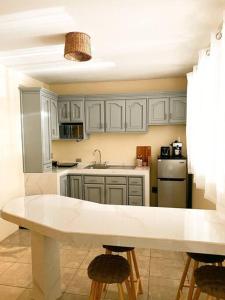 QuesadaCasa Boho的厨房配有白色橱柜和白色台面