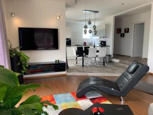 马卡尔斯卡Apartment Dora的客厅配有黑色真皮座椅和电视