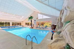 Basse-GoulaineLes Jardins de la Muse, piscine couverte, spa et fitness的大型建筑中的大型游泳池