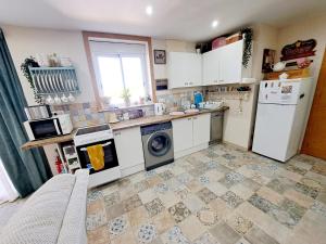 Casa de los Suenos Granada的厨房配有白色家电,铺有瓷砖地板。