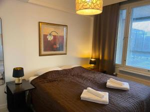 赫尔辛基Gella Serviced Apartments Office的一间卧室配有一张床,上面有两条毛巾