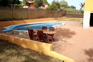 Casa independiente , piscina, naturaleza y relax的游泳池旁的桌椅