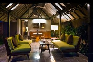 坎古库米亚别墅的客厅配有绿色椅子和桌子