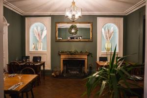 WedmoreThe George Inn Wedmore的一间带壁炉和镜子的用餐室