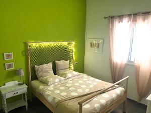 蓬塔德尔西达尔戈Un Paraiso En Tenerife的一间卧室设有一张带绿色墙壁和窗户的床。