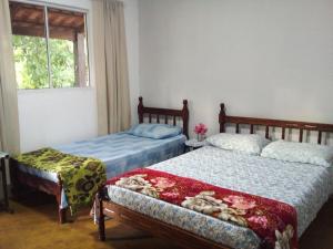 皮雷诺波利斯Recanto São Francisco de Assis的一间卧室设有两张床和窗户。