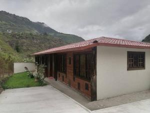 CusúaEl Rancho Viejo de José, suit de una habitación的山上有红色屋顶的小房子